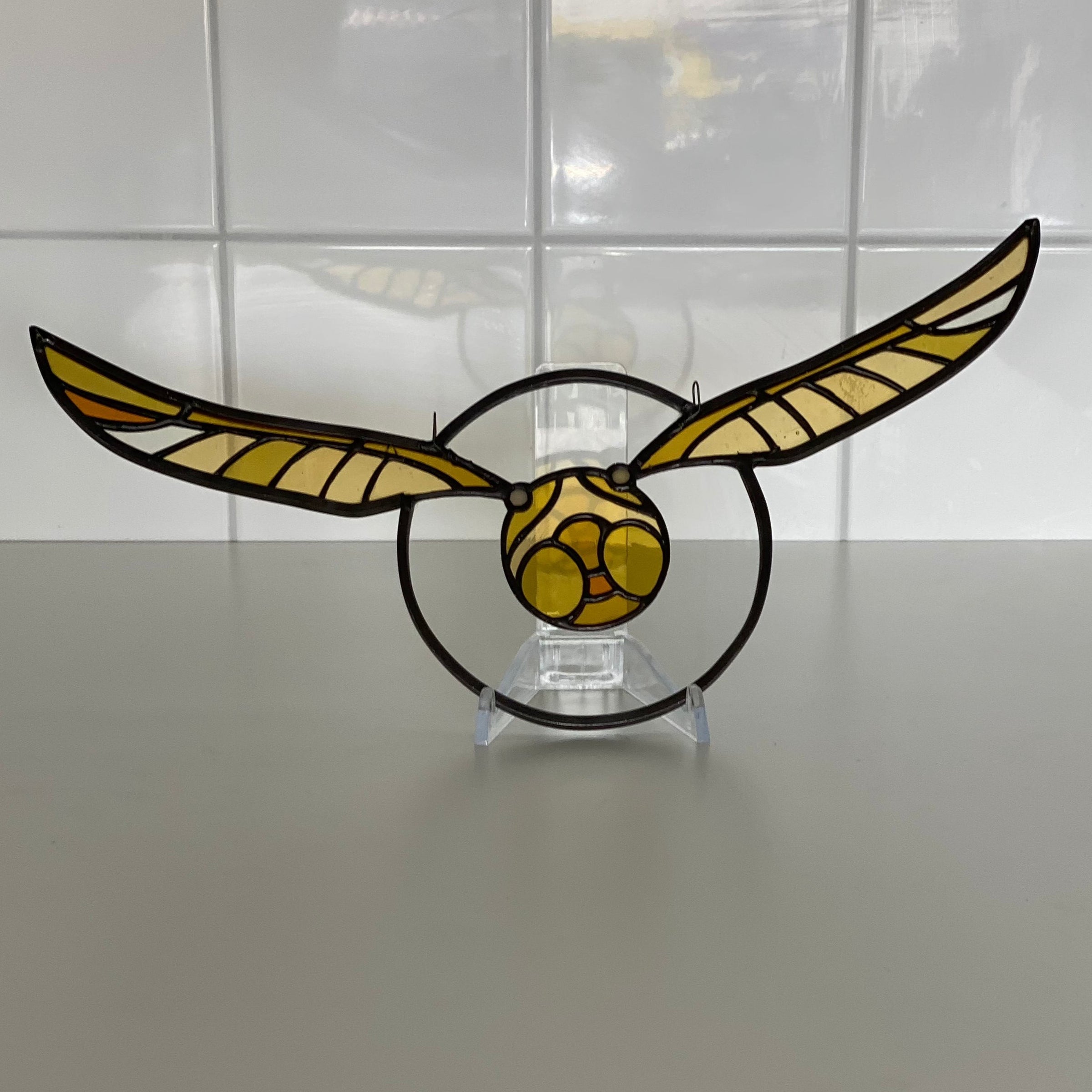 golden snitch stained glass suncatcher on display stand