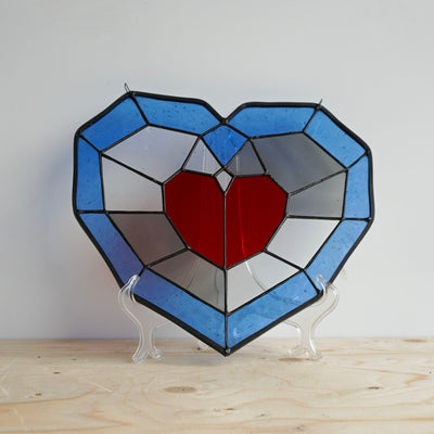 piece of heart stained glass on display stand front view